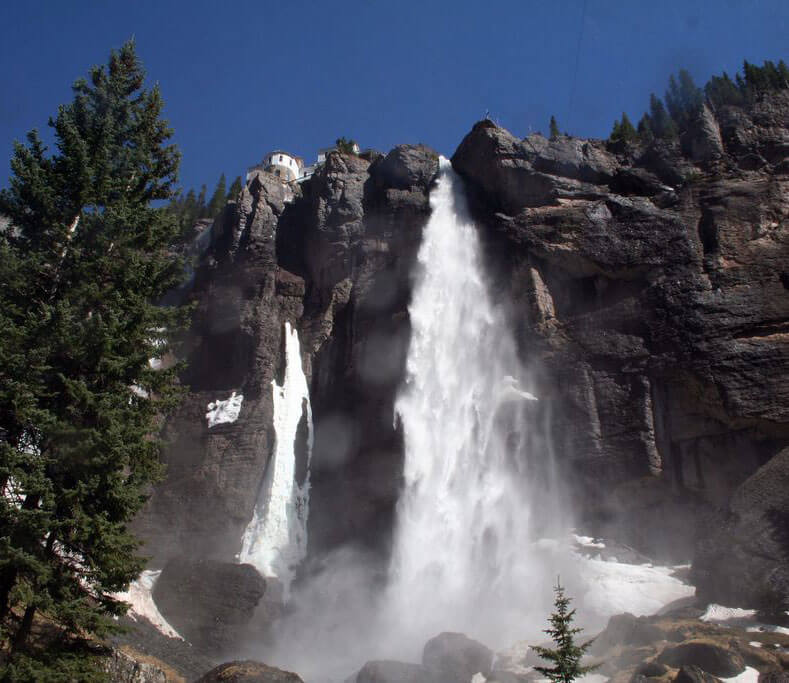 move to colorado veil falls tourist attraction large white waterfall over cliff with pine tree