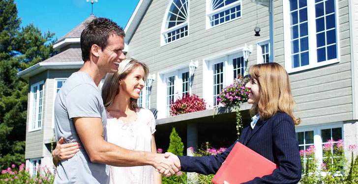 colorado buyers agent shaking hands with couple in front of their new home